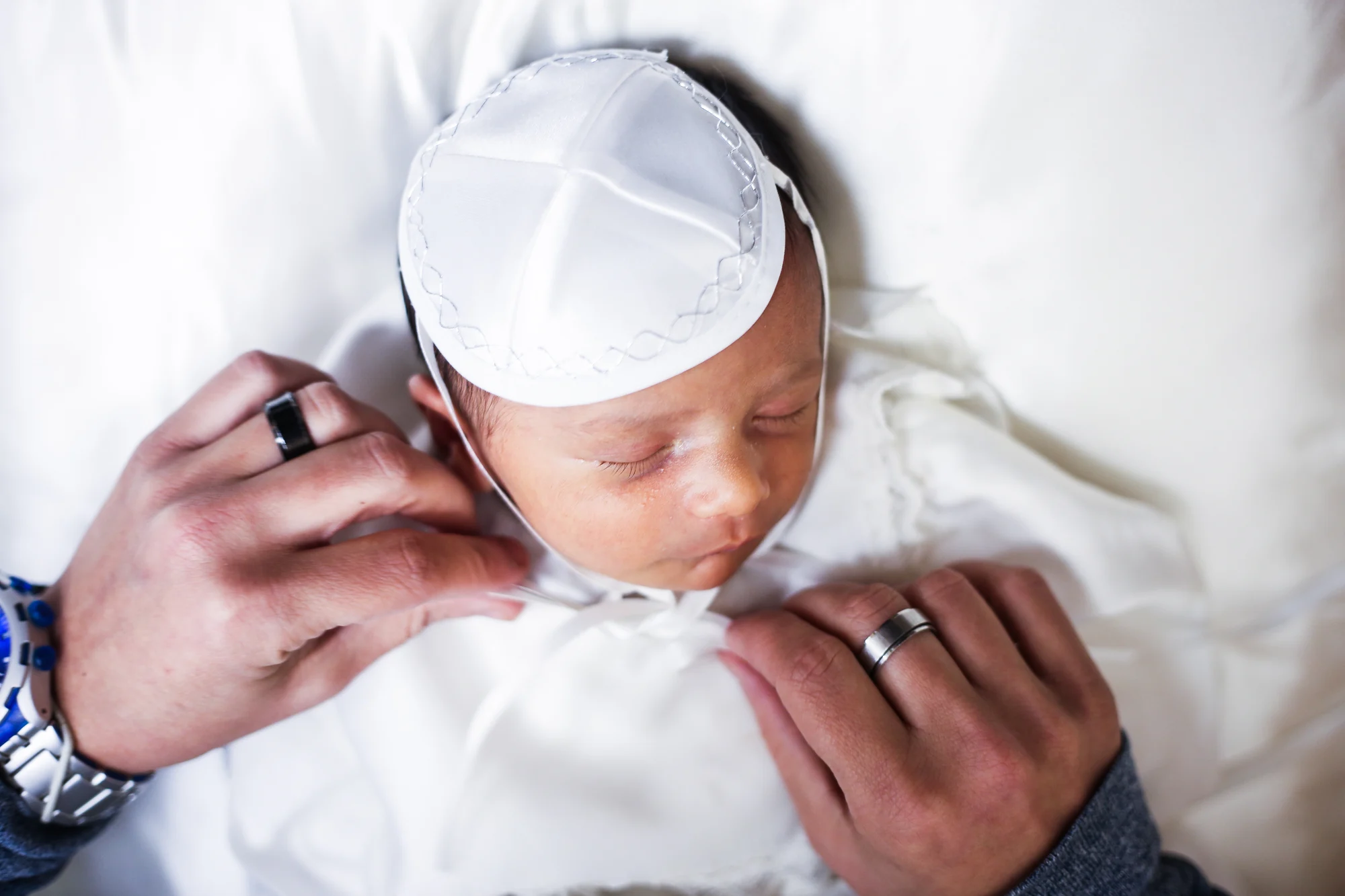 Les mains du père nouent la kippa